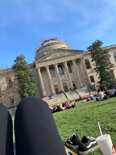 Lounging on the grass with shoes off and coffee in hand outside Wilson Library on the UNC-CH campus on a warm day.