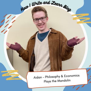 Learning Coach Aidan stands with his thumbs up in a frame that says "Aidan - Philosophy & Economics Plays the Mandolin" The frame has a blue background with yellow and red dashes