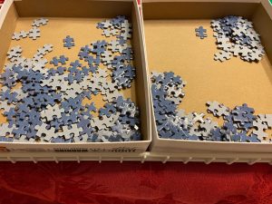 A sea of blue puzzle pieces inside a box. 